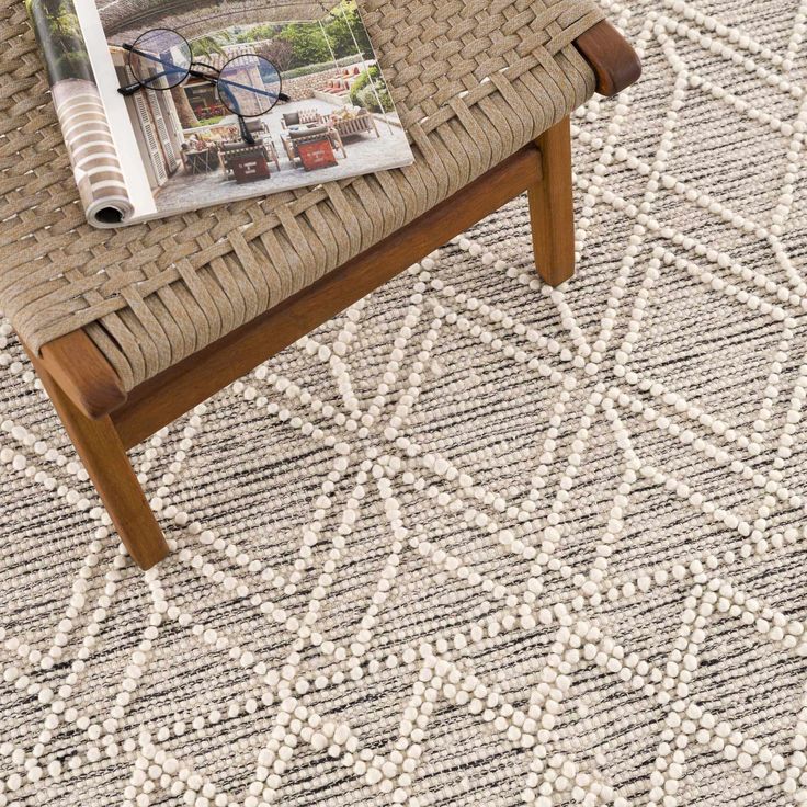 a magazine sitting on top of a wooden bench in front of a woven tablecloth