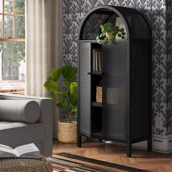 a living room with a couch and bookcase in the corner next to a window