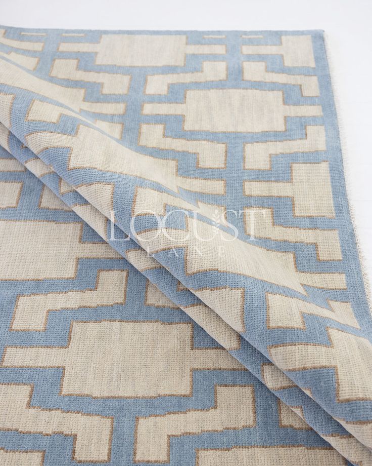 a blue and beige area rug with an interlocked design on the bottom side