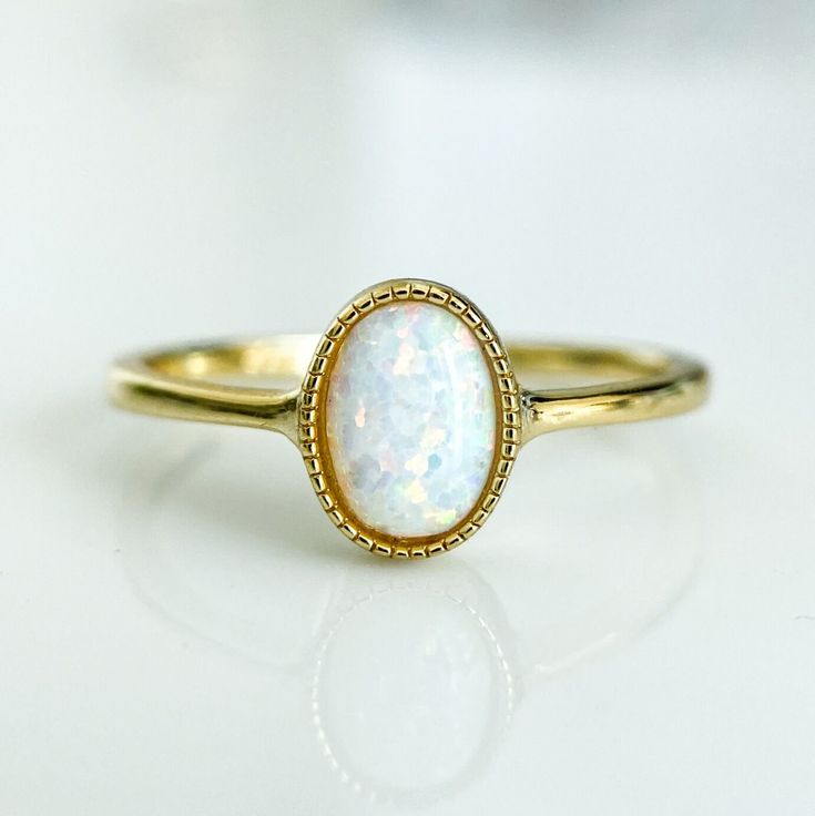 A dreamy and romantic opal ring featuring a round cut in a bezel setting and an elegant polished band in 14K gold plating over sterling silver.
A delicate vintage design and a glowing opal stone make this a truly unique piece. Vintage Wedding Rings Opal, Big Opal Ring, Timeless Adjustable Oval Rings, Stackable Oval 14k Gold Jewelry, Delicate Gold Gemstone Ring, Delicate Gold Rings With Gemstones, Classic Stackable 14k Gold Jewelry, Classic Halo Ring With Round Stone For Promise, Classic Stackable Jewelry Gift