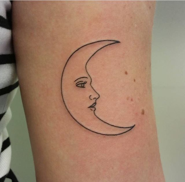 a woman's arm with a crescent moon tattoo on the left side of her body