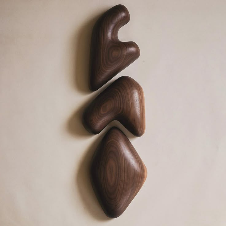 three pieces of wood sitting on top of a white wall next to each other in the shape of hearts