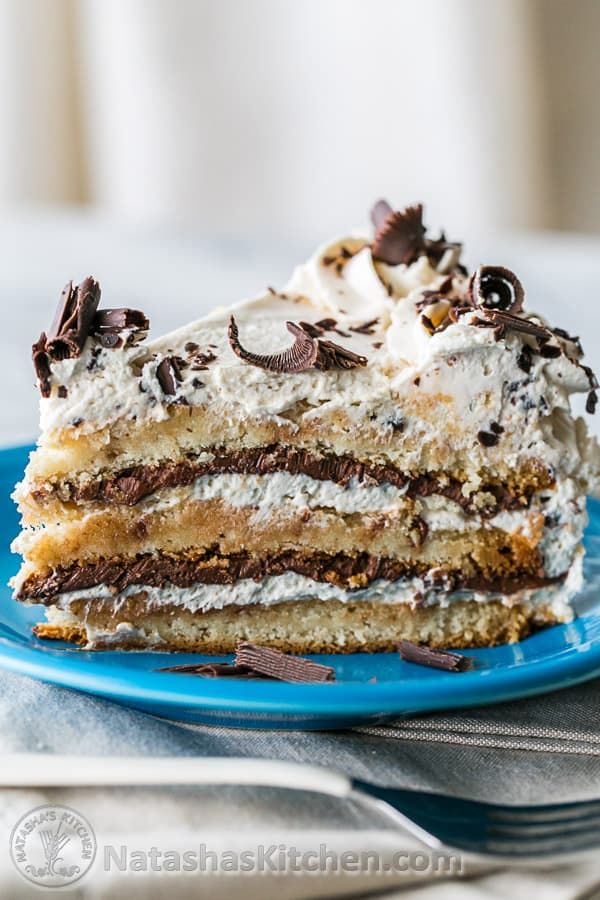 a piece of cake on a blue plate with white frosting and chocolate sprinkles