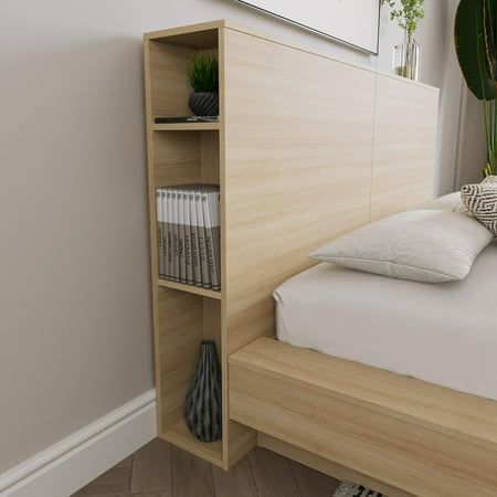 a bed with a book shelf next to it and a plant on the wall behind it