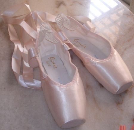 three pairs of ballet shoes sitting on top of a counter