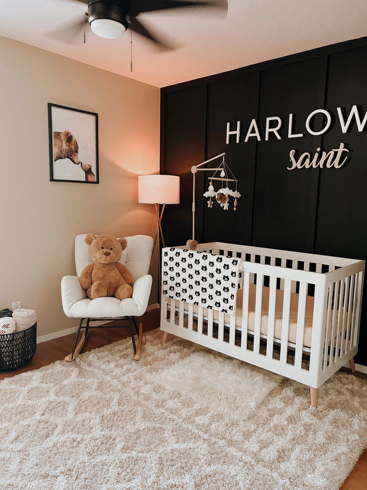 a teddy bear sitting in a white crib next to a wall with the name harry saint on it