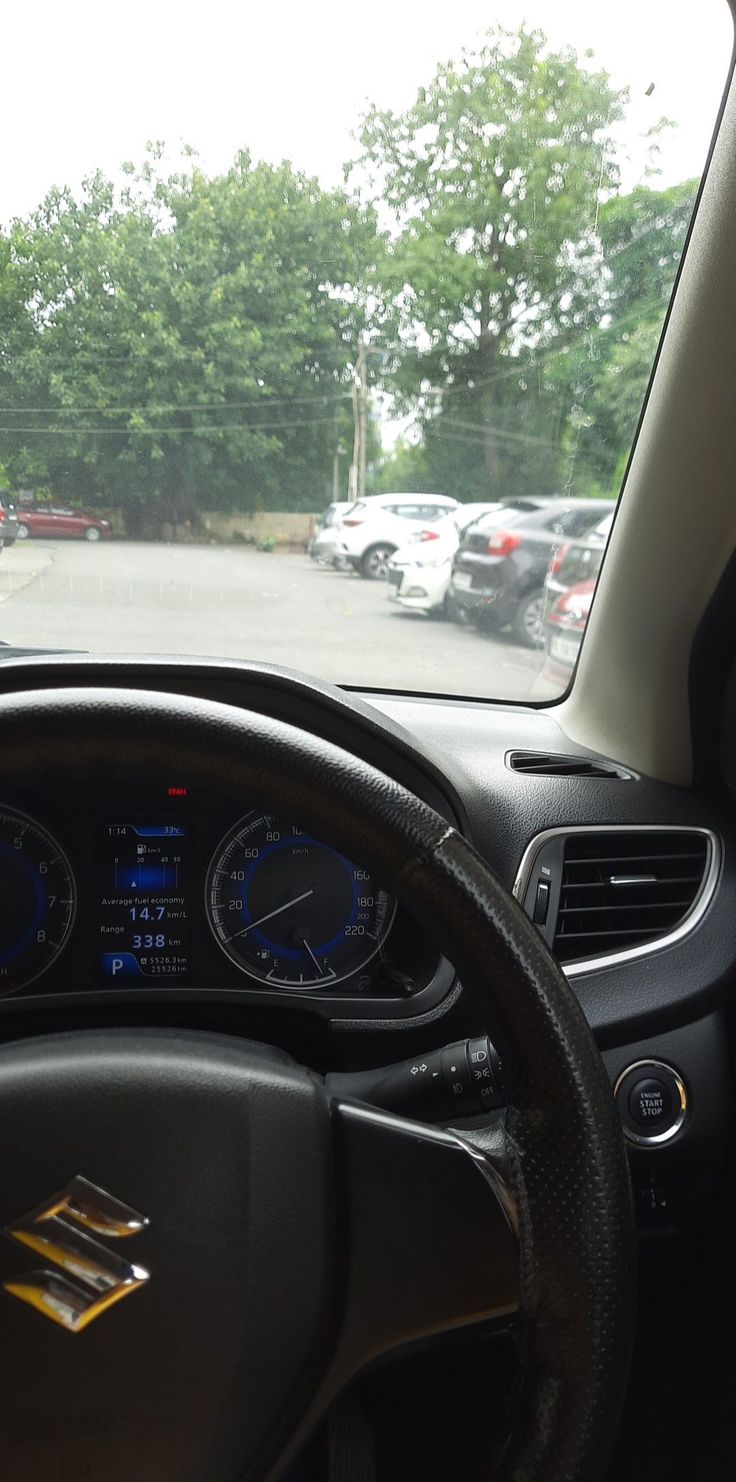 the dashboard of a car with several cars in the background