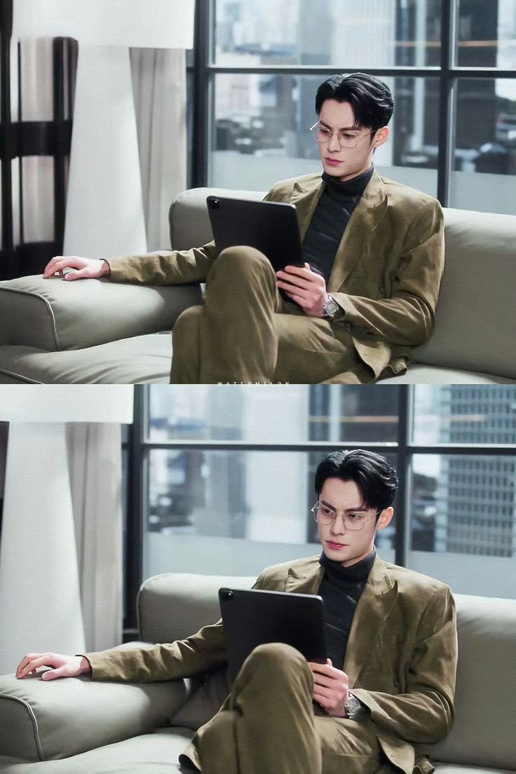 a man sitting on top of a couch holding a tablet