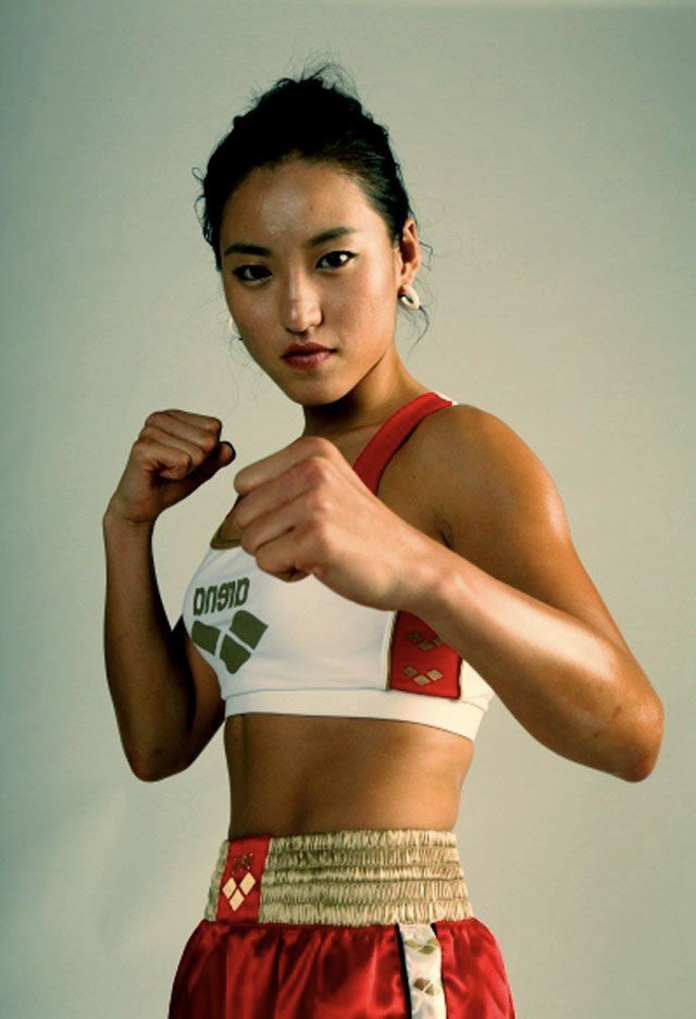 a woman in a red and white top flexing her muscles