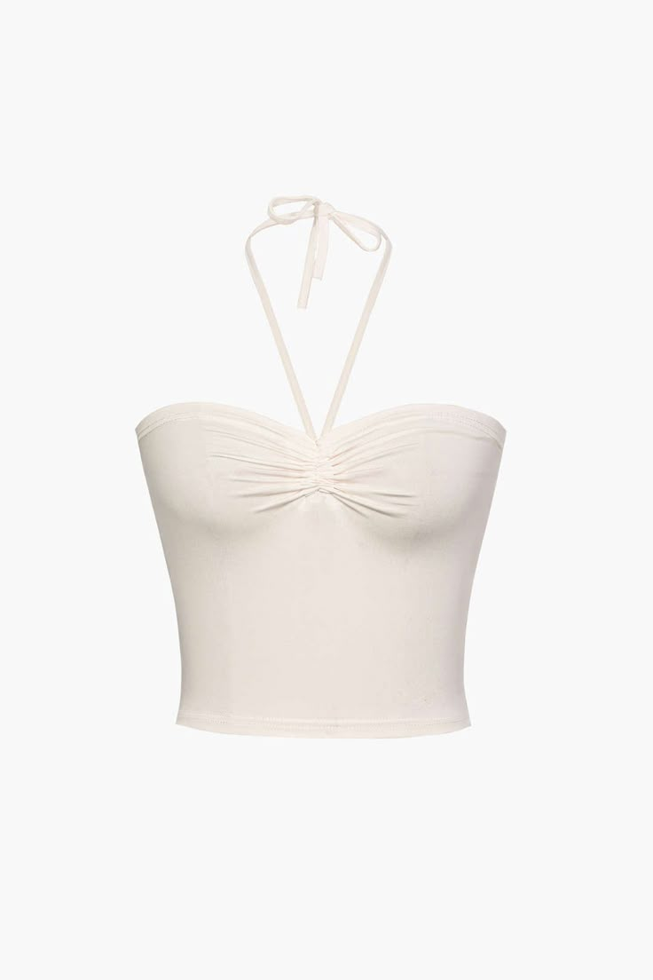 a white crop top with a bow at the neck and straps around the bustle