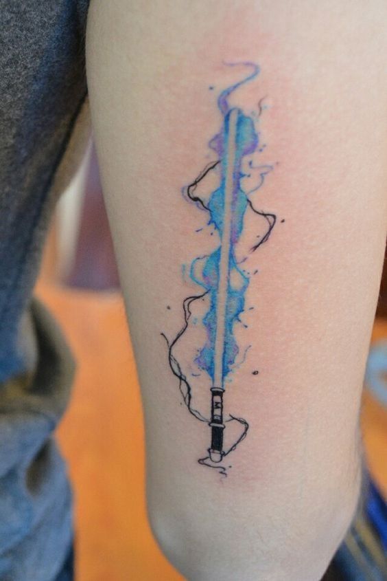 a person with a star wars tattoo on their arm and the lightsaben is painted blue