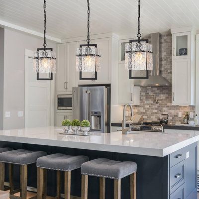 a kitchen island with four stools in front of it