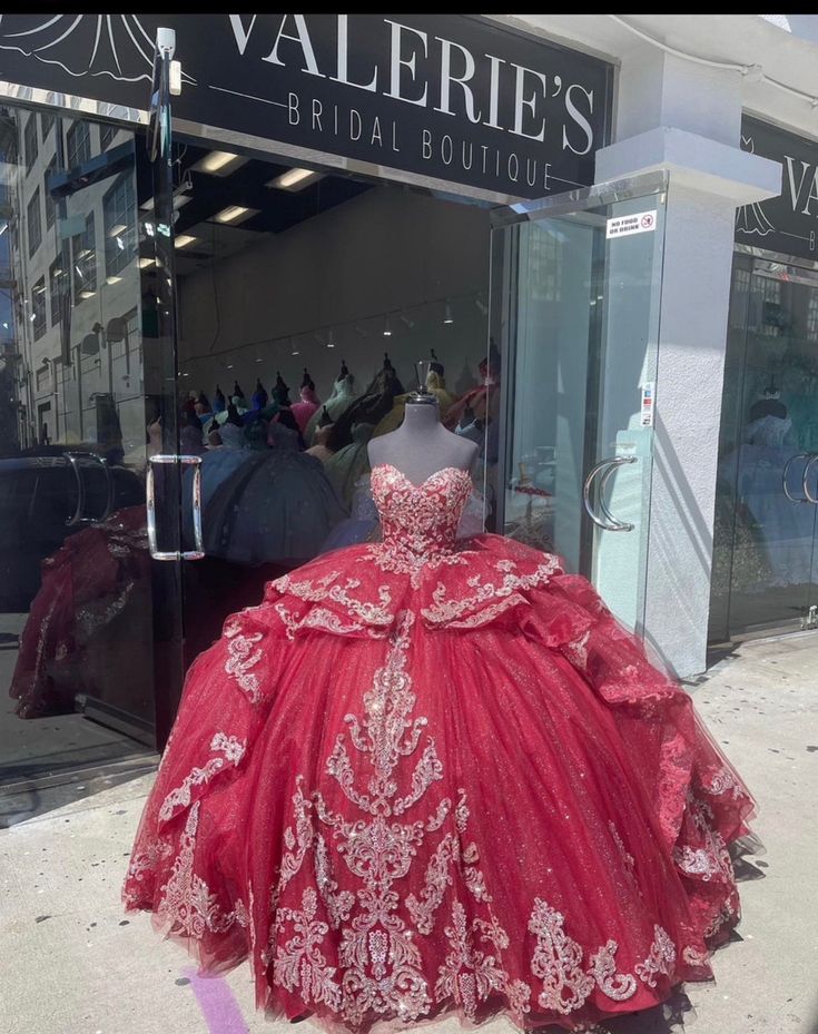 a red ball gown on display in front of a store