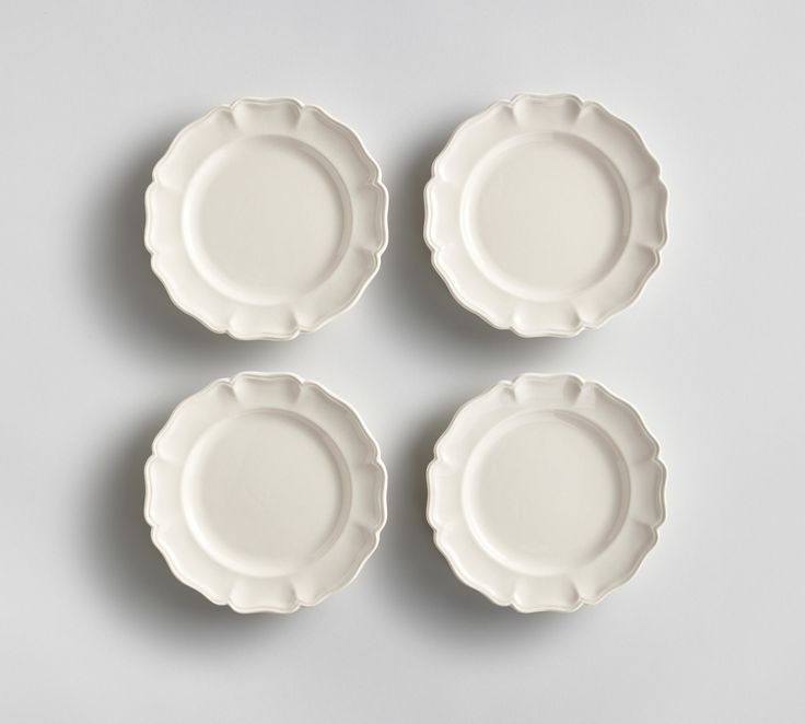 four white plates sitting on top of each other