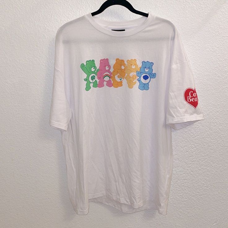 Care Bears X Romwe Collaboration White Short Sleeve Tee Shirt Colorful Care Bear Image On The Front Red Heart Care Bears Logo On Left Sleeve Never Worn, Nwt Size L P Casual White Printed Shirt, Casual Tops With White Funny Print, Trendy White Shirt For Streetwear, Fun Printed Tops For Streetwear, Casual White Print Short Sleeve Shirt, Fun White T-shirt For Streetwear, White Relaxed Fit Trendy Shirt, Trendy White Relaxed Fit Shirt, Trendy White Shirt With Relaxed Fit