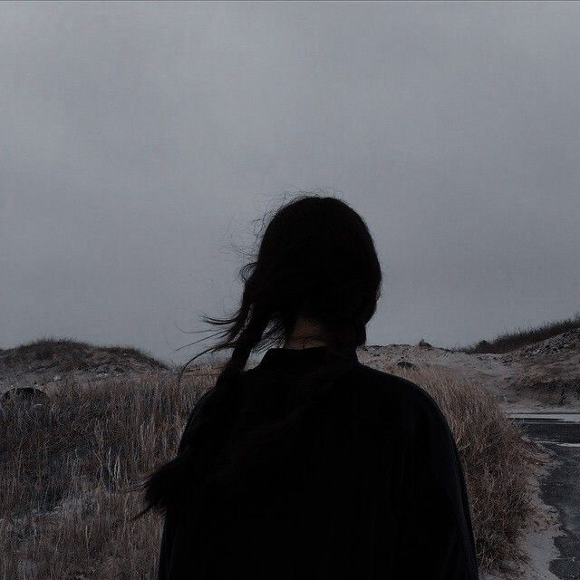 a woman standing in the snow with her hair blowing in the wind