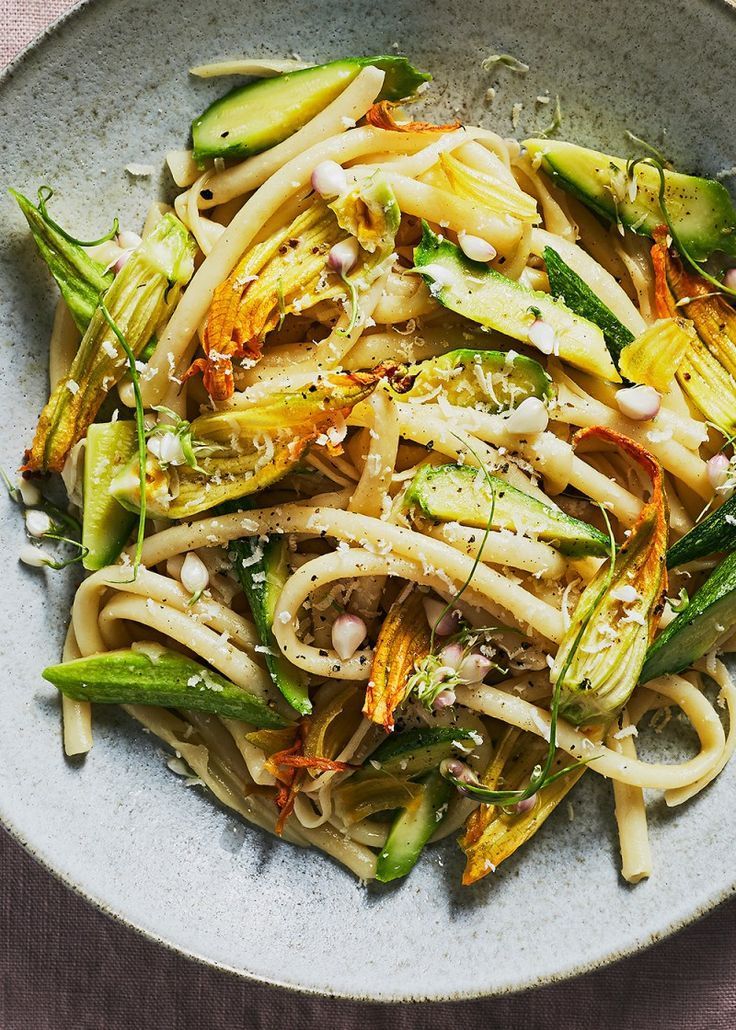 a white bowl filled with pasta and vegetables