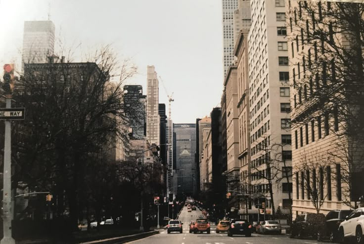 an empty city street with tall buildings in the background