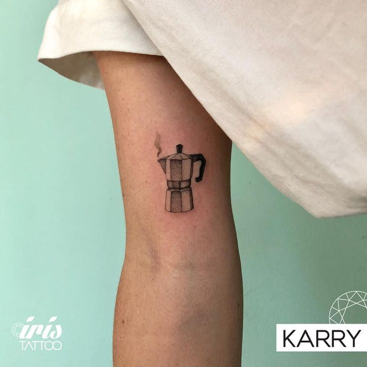 a tattoo on the arm of a person with a coffee pot in front of them