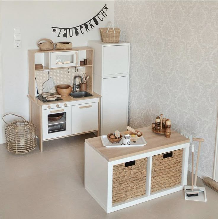 a small kitchen with white cabinets and baskets on the counter, next to an oven