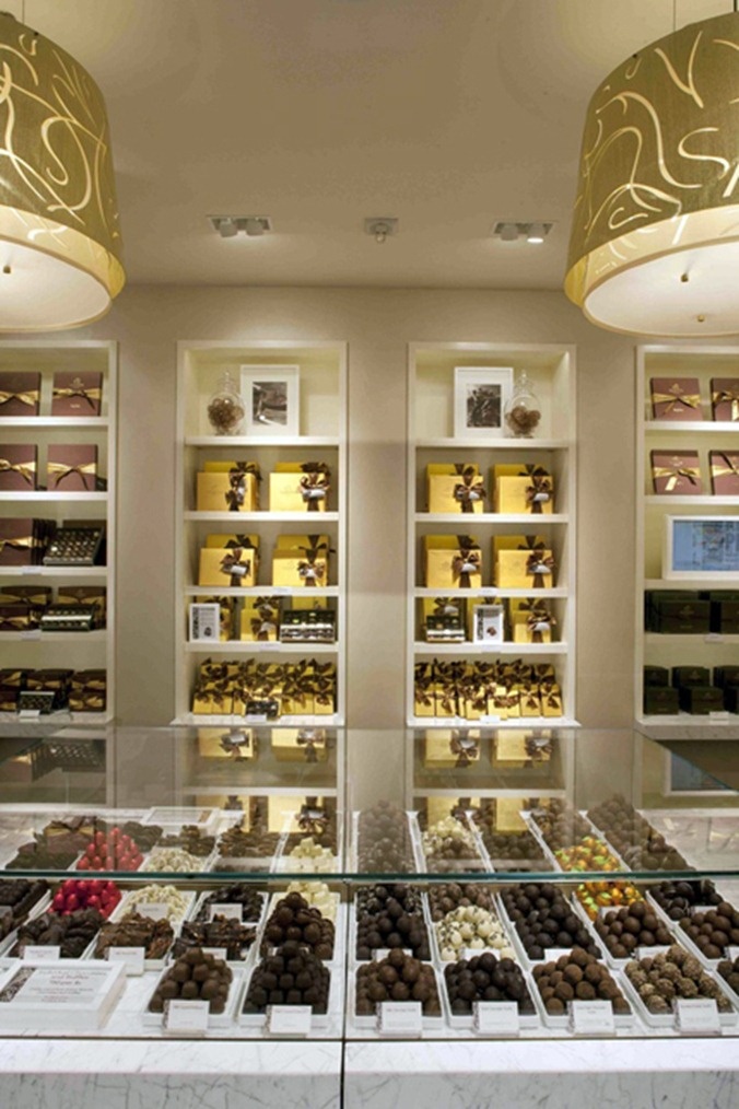 a display case filled with lots of different types of chocolates on top of glass shelves