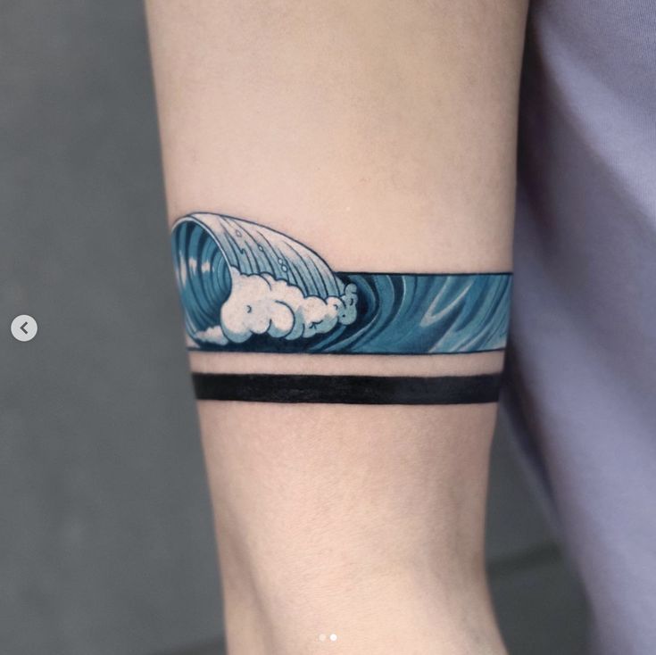 a person with a tattoo on their arm holding onto a surfboard and the wave