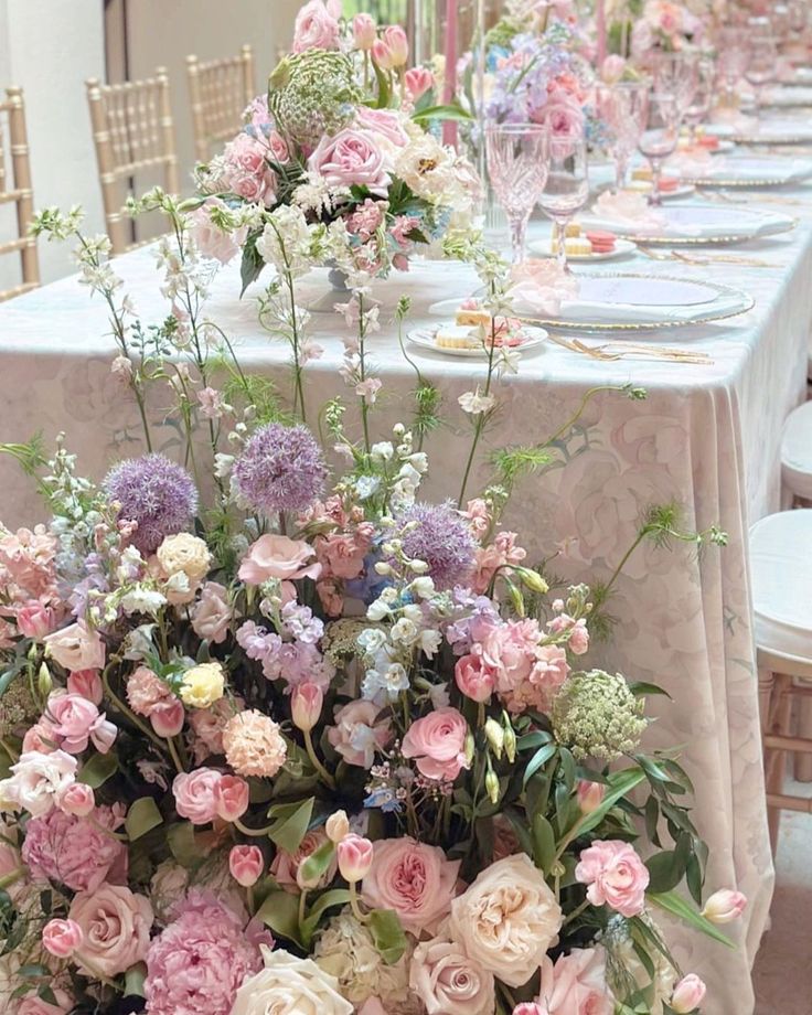 the table is set with flowers and place settings