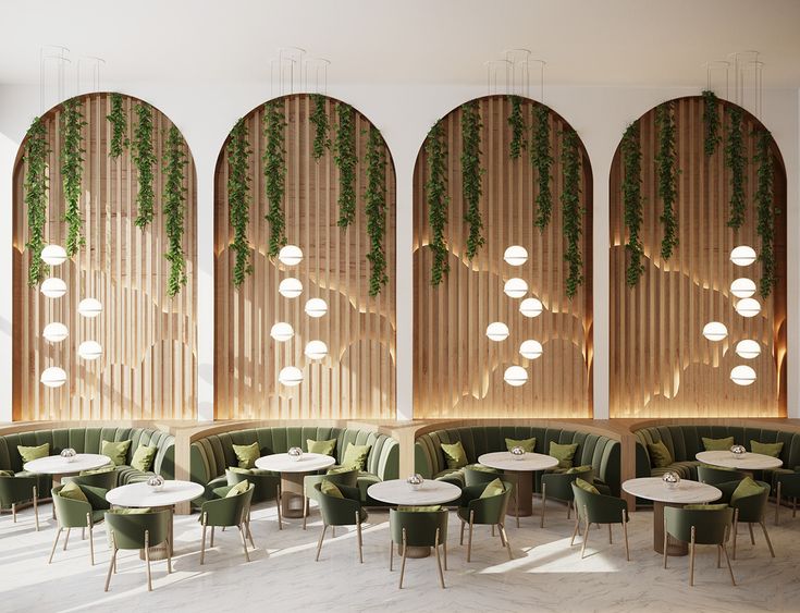 an empty restaurant with round tables and green velvet booths, hanging plants on the wall