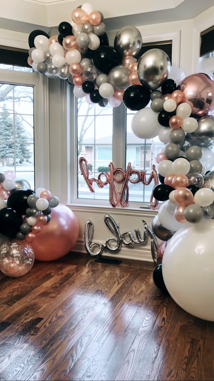 the balloon arch is decorated with black, white and rose gold balloons for a party