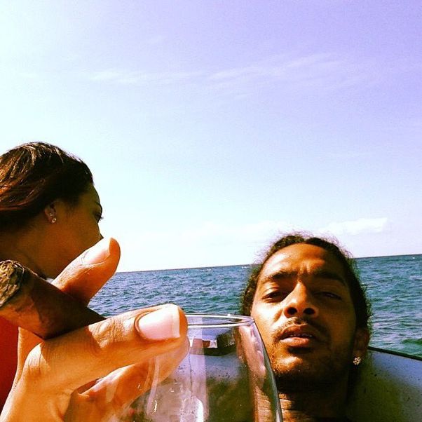 a man holding a wine glass next to a woman on a boat in the ocean