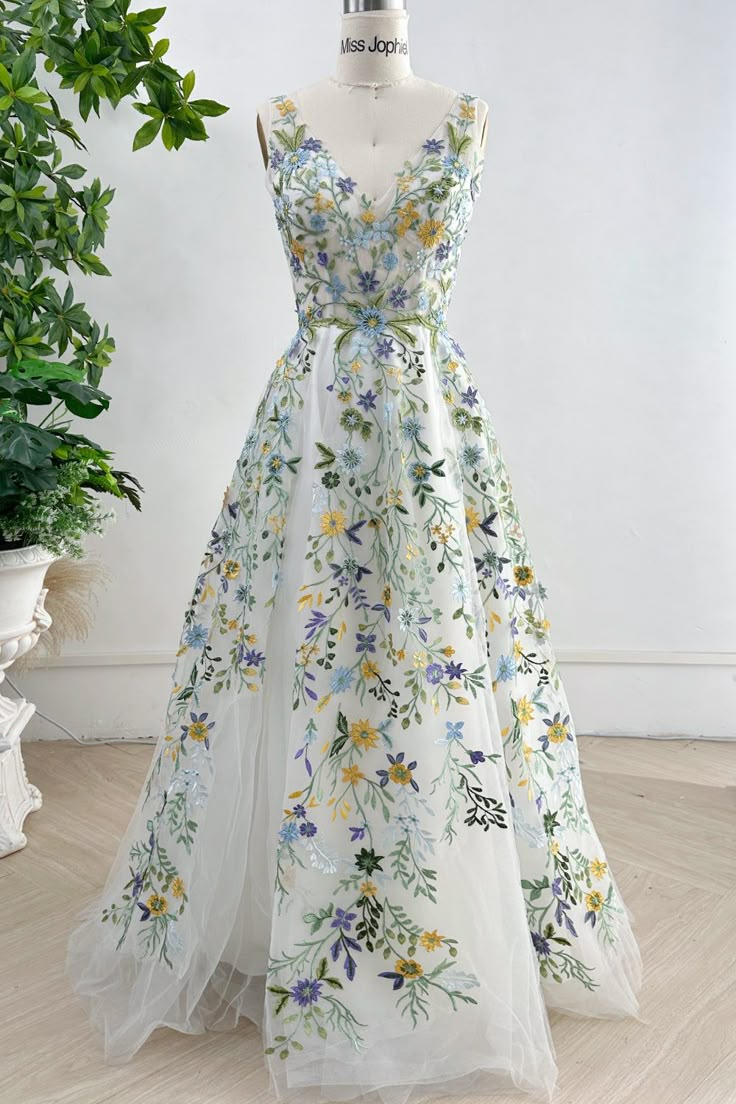 a dress on a mannequin in front of a potted plant and white wall