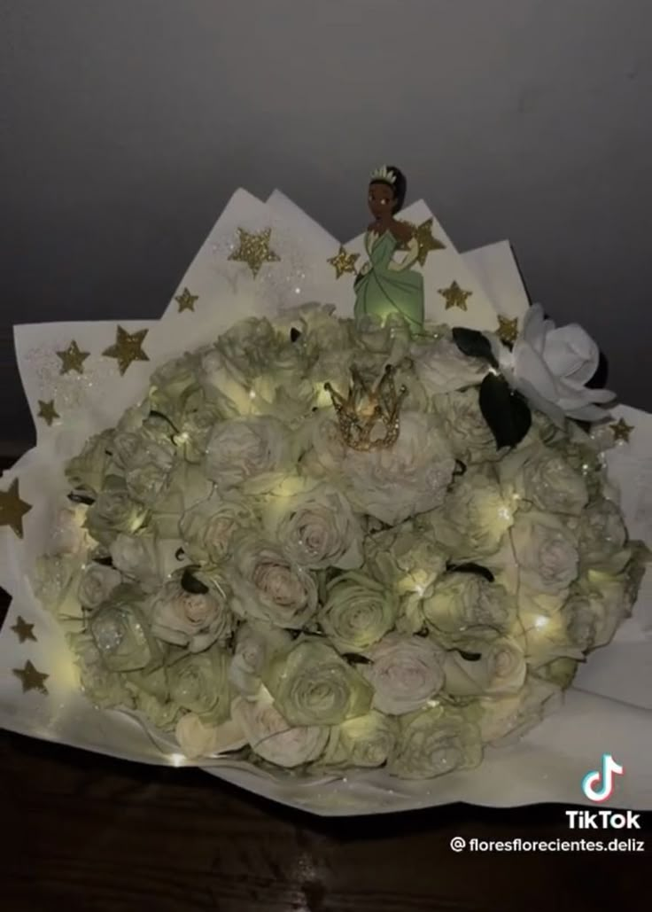 a bouquet of white roses with fairy lights