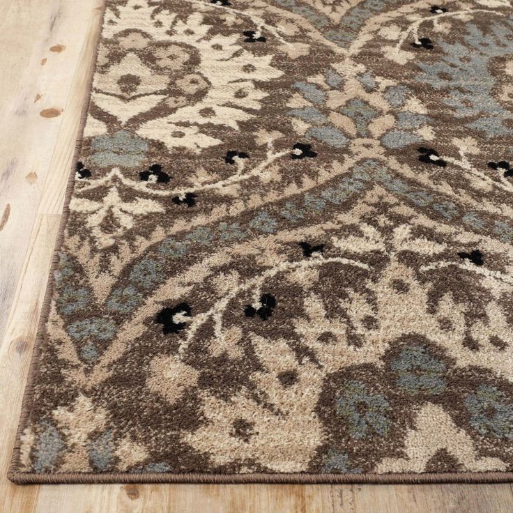 a brown and blue rug on top of a wooden floor