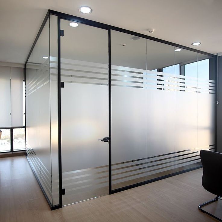 an office with glass walls and wooden floors