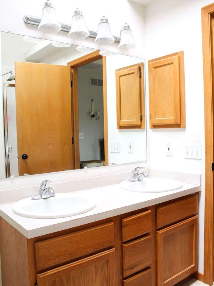 a bathroom with double sinks and wooden cabinets