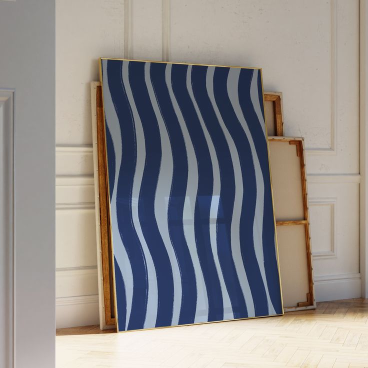 a blue and white striped wall hanging next to an open bookcase on the floor