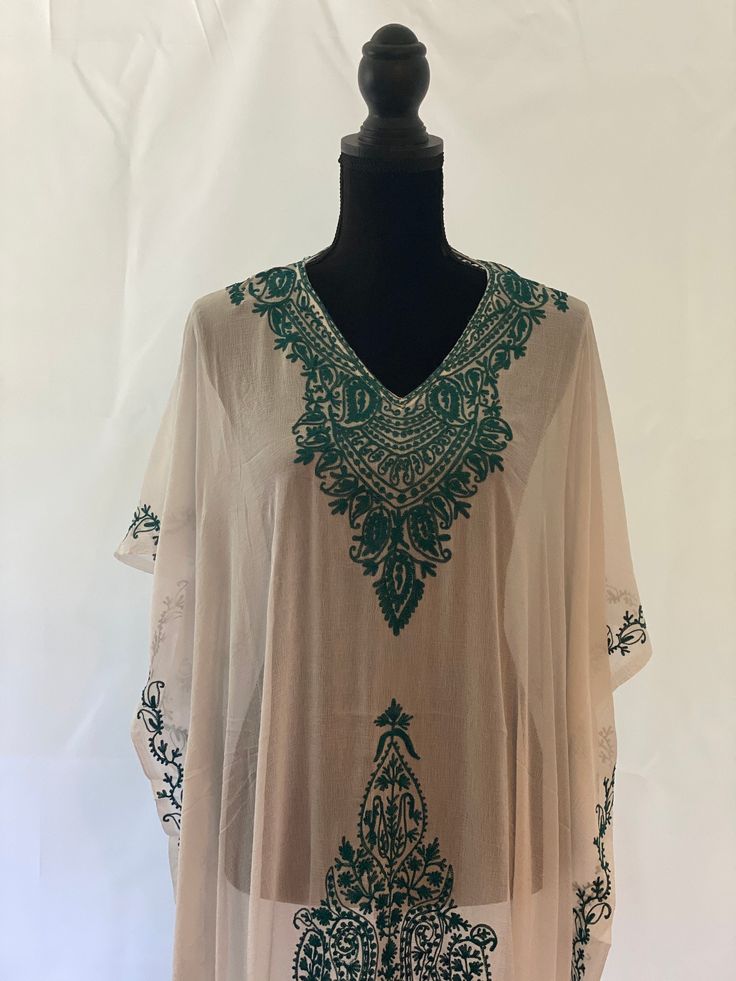 Embroidered Kashmiri Georgette Kaftan - One Size, Long. This Kaftan makes a perfect style statement for summer and your beach vacation. This is a bohemian style maxi dress that can be perfect as a swim coverup or for your beach vacations. Color: White with Green Embroidery Fits small to plus sizes. Measurements with room for comfort: Chest up to: 50 inches Length: 55 inches Care: Hand wash or dry clean only. V-neck Embroidered Maxi Dress For Summer, Embroidered Kaftan For Beach Cover-up, Floral Embroidered Kaftan For Spring Beach Cover-up, Green Maxi Beachwear Cover-up, Traditional V-neck Maxi Dress For Summer, Flowy Beige Kaftan For The Beach, Green Flowy Maxi Length Cover-up, Flowy Green Maxi Length Cover-up, Summer V-neck Tunic With Chikankari Embroidery