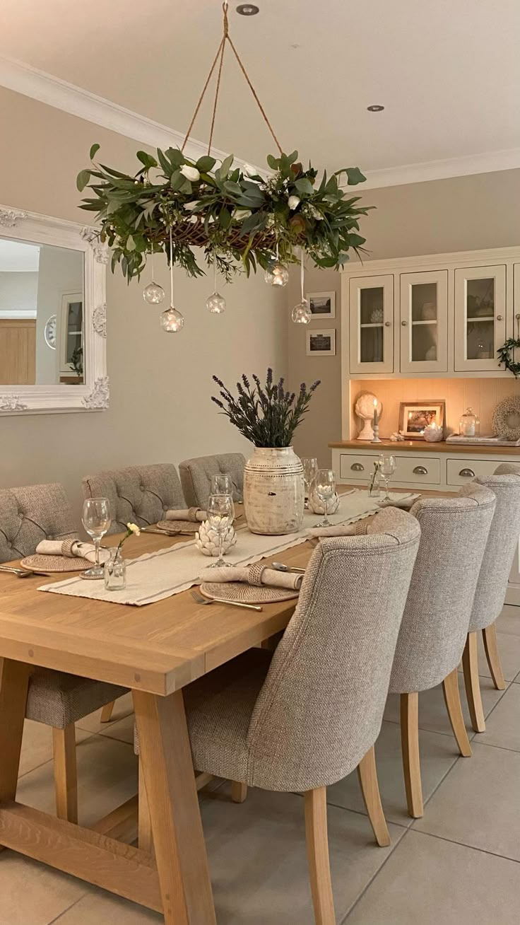 a dining room table with chairs and a potted plant hanging from it's ceiling