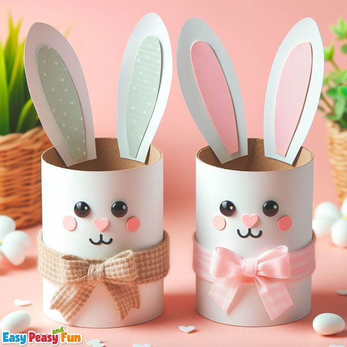 two toilet paper rolls with bunny ears and bows on them, sitting next to each other