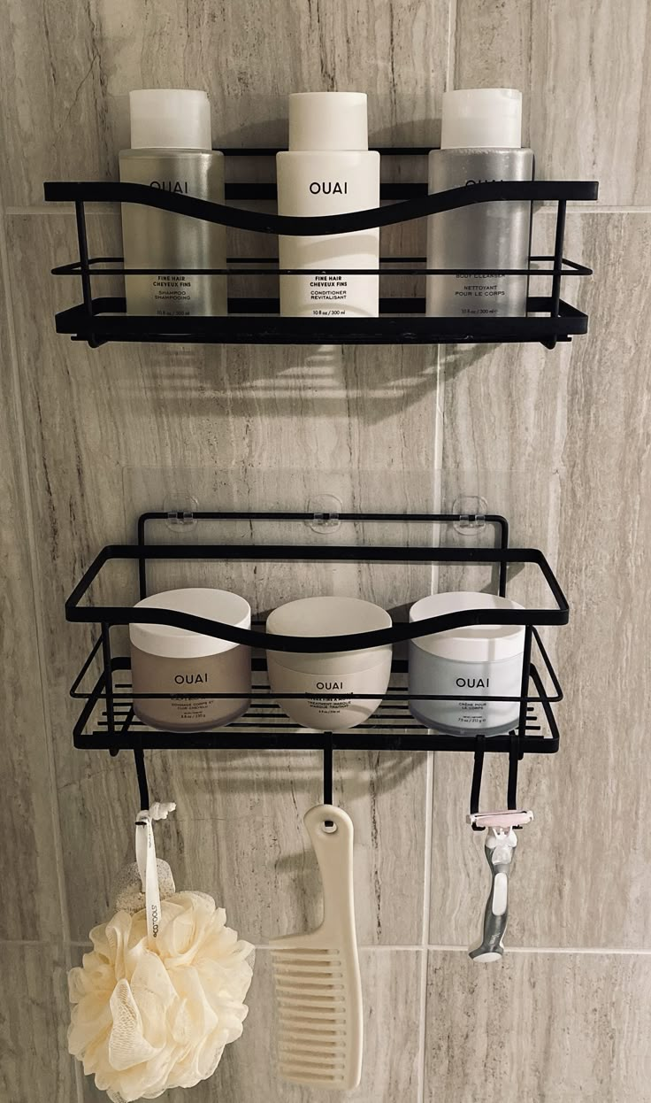 two black shelves with hair products on them and a white flower in the foreground