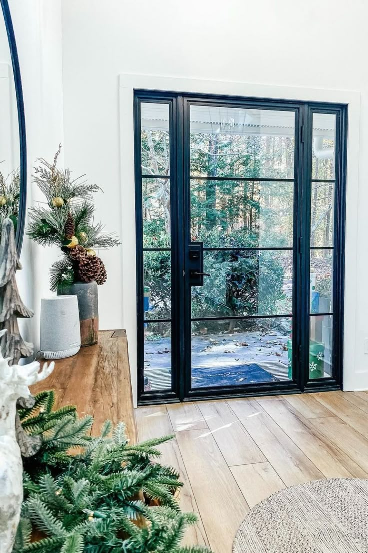 the inside of a house with wooden floors and glass doors that lead to a patio