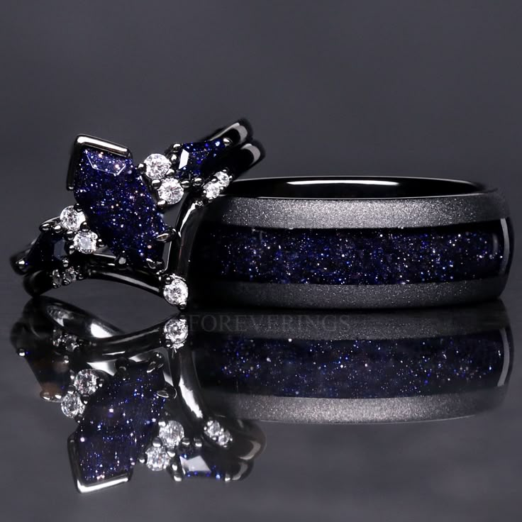 two rings with blue and white glitter on them, one has a bow tie in the middle