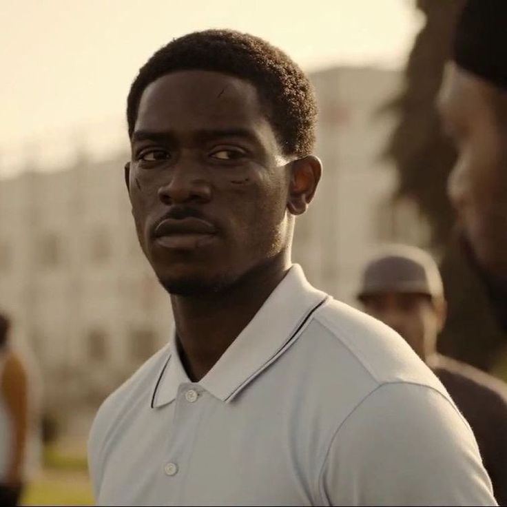 a man in white shirt standing next to another man with his head tilted back and looking at the camera