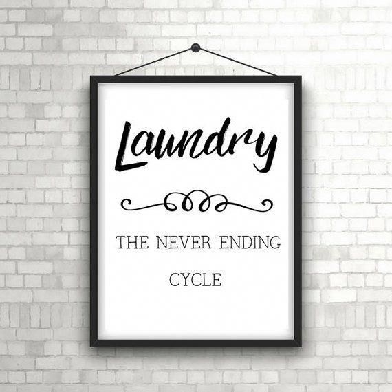 a white brick wall with a black frame hanging on it and the words laundry, the never ending cycle