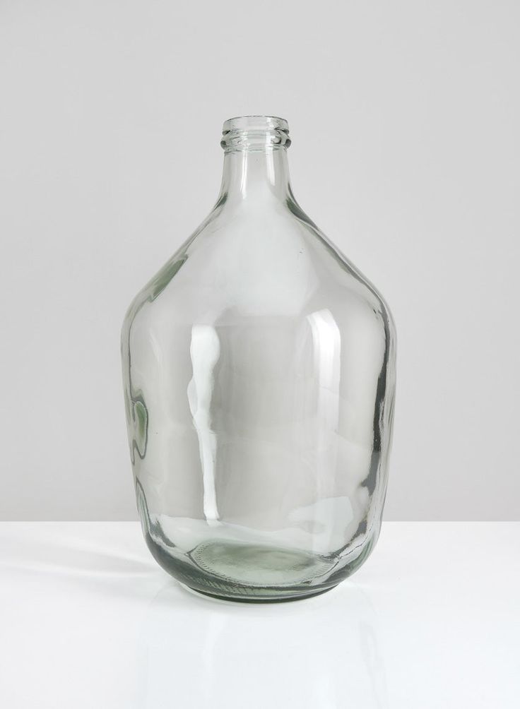 a clear glass bottle sitting on top of a white table