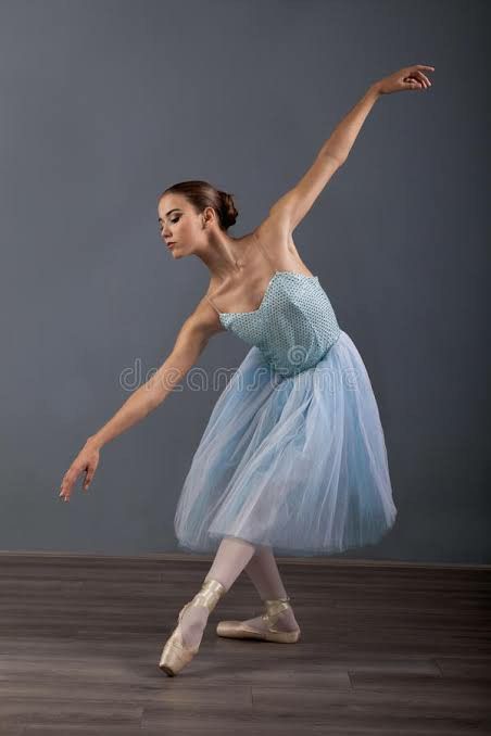 a young ballerina in a blue tutu and ballet shoes