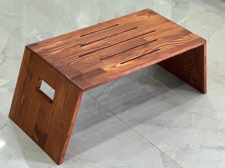 a wooden step stool sitting on top of a white floor