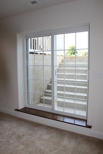 an empty room with sliding glass doors and carpeted flooring in front of the window