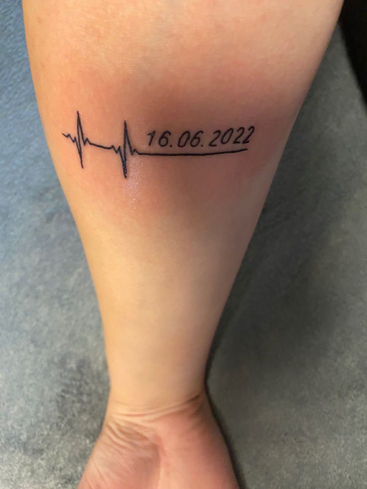 a woman's foot with a heartbeat tattoo on it that reads 10 00 22