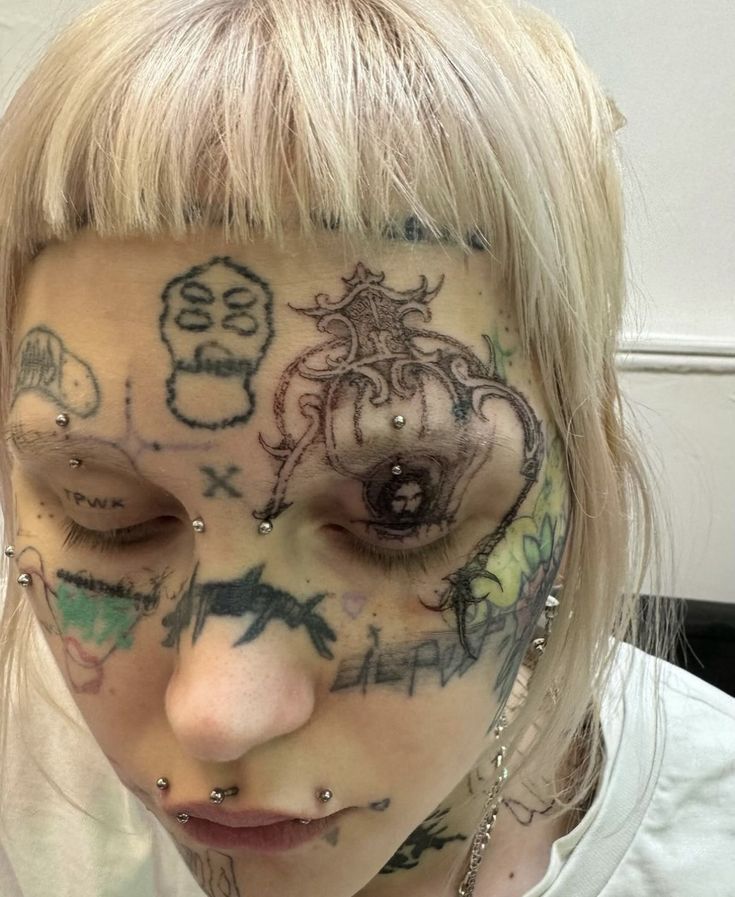 a woman with tattoos on her face and nose